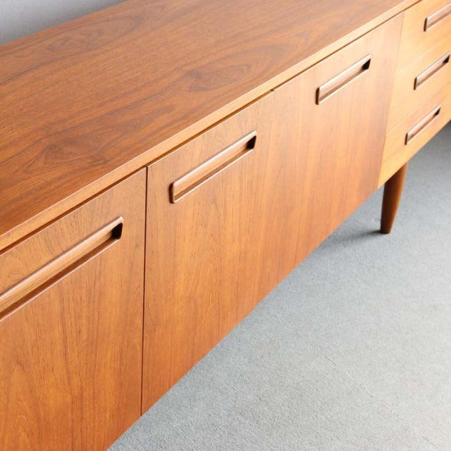 Vintage teak sideboard with smooth wood grain, mid-century British style, angled legs, Denmark design influence.
