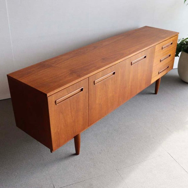Mid-century vintage teak sideboard with British-Denmark design, featuring rich wood grain, tapered legs, and recessed.