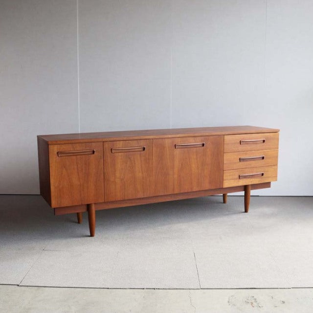Mid-century vintage teak sideboard with rich wood grain, British-Denmark style, featuring four doors and three drawers on.