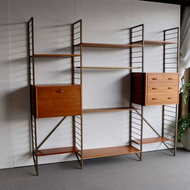 Vintage teak Ladderax shelving unit with British mid-century design, featuring adjustable shelves, drawers, and a cabinet,.
