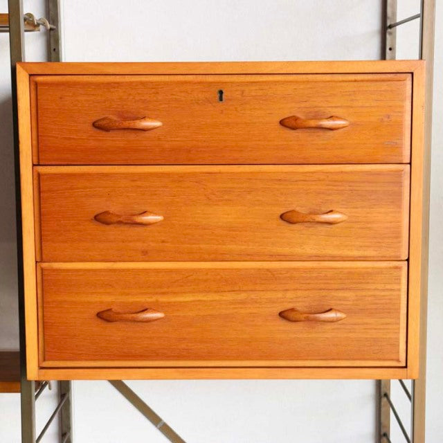 Vintage teak Ladderax unit shelf cabinet with three drawers, smooth wood grain, British mid-century design, elegant rounded.