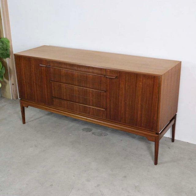 Vintage A.H.McIntosh teak sideboard with mid-century British design, rich wood grain, tapered legs, and recessed handles.
