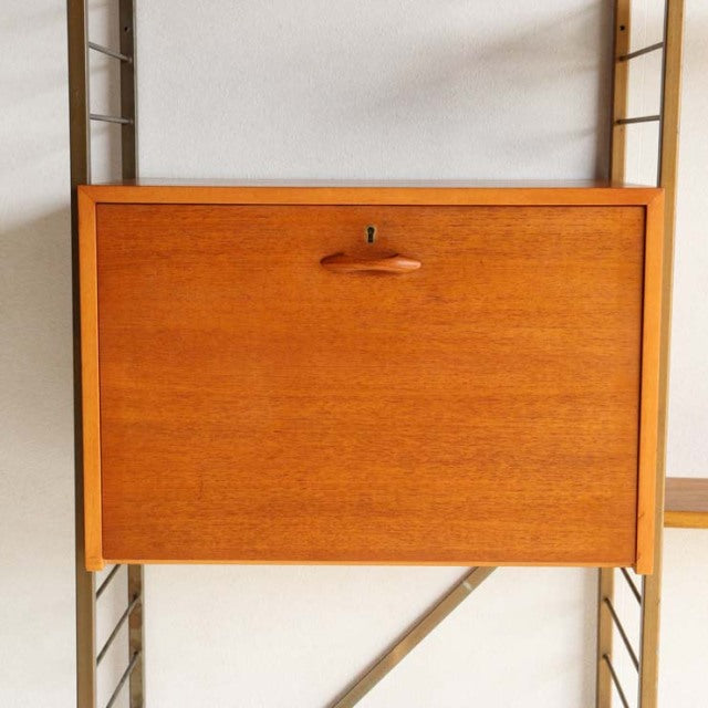 Mid-century British teak vintage Ladderax unit shelf with rich wood grain and rounded wooden pull handle.