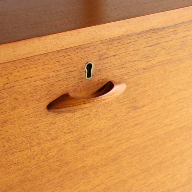Close-up of mid-century British Ladderax teak unit shelf drawer with smooth curved handle and keyhole detail showing fine.