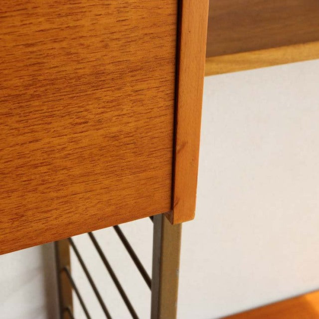 Close-up of vintage teak wood grain on British Ladderax mid-century unit shelf with metal frame and clean lines.