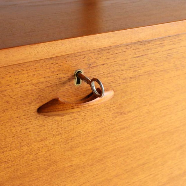 Vintage teak Ladderax unit shelf drawer with smooth wood grain, recessed handle, and brass key lock, British mid-century.