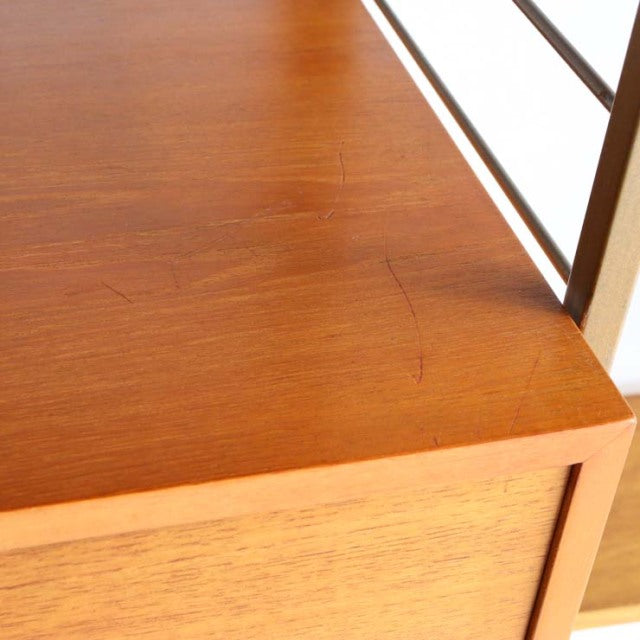Close-up of vintage teak ladderax shelving unit corner showing rich wood grain and smooth mid-century British design with.
