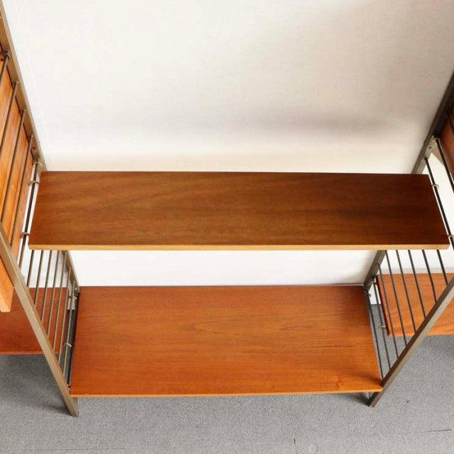 Vintage teak Ladderax shelving unit with British mid-century design, vertical metal supports, and warm wood grain finish.