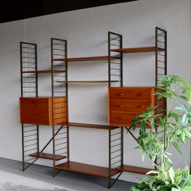 Vintage teak Ladderax shelving unit with British mid-century design, metal ladder sides, multiple shelves, and two wood.