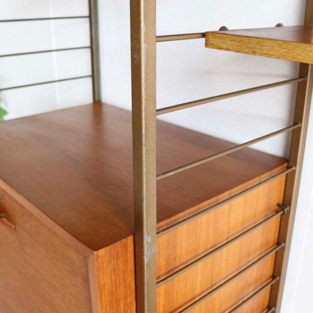 Vintage teak Ladderax shelving unit with British mid-century design, clean wood grain, and metal frame details.