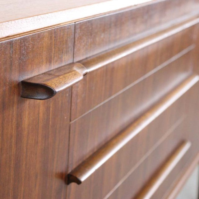 Close-up of vintage A.H.McIntosh teak sideboard drawer showcasing rich wood grain and sculpted mid-century British design.