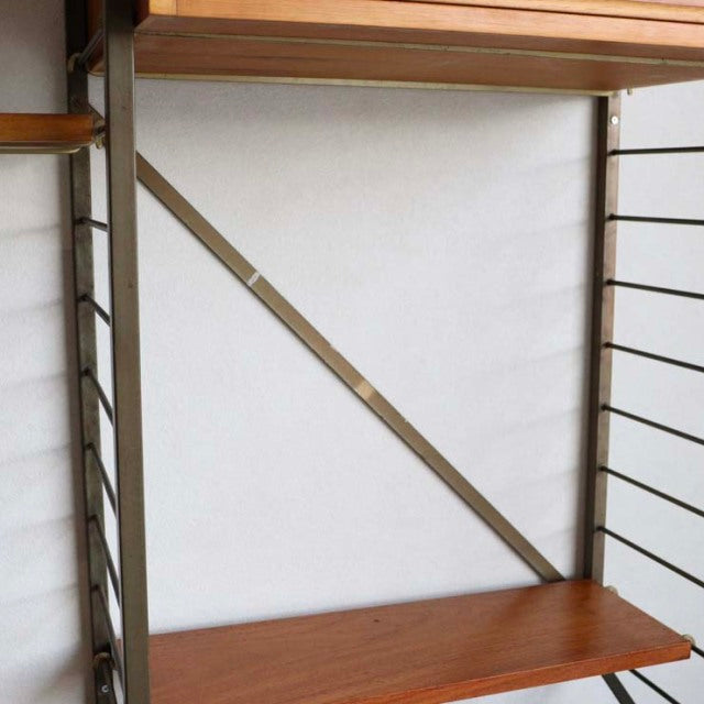 Mid-century vintage teak Ladderax shelving unit by British Staples, sleek wood grain with slender metal frame and.
