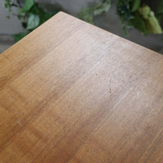 Close-up of vintage British mid-century teak sideboard top with smooth wood grain and warm honey tones.