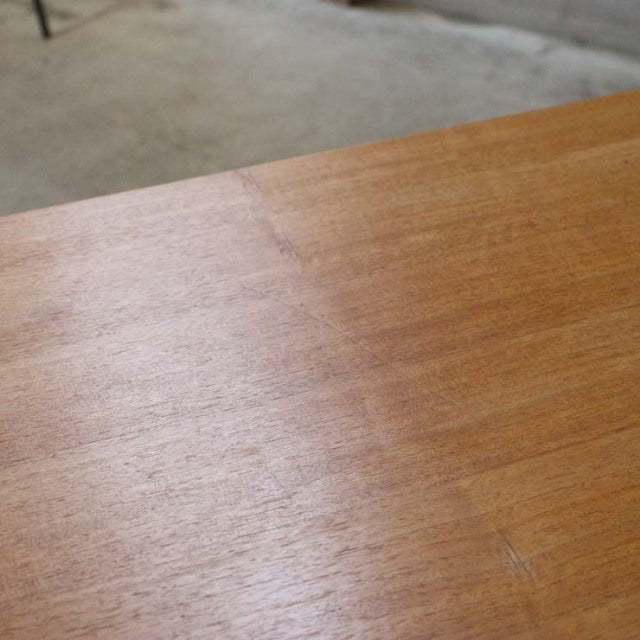 Close-up of vintage A.H. McIntosh teak sideboard top showcasing smooth mid-century British wood grain and finish.
