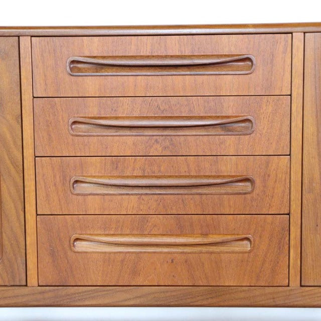 British vintage mid-century teak sideboard with three drawers, smooth wood grain, and integrated curved handles.