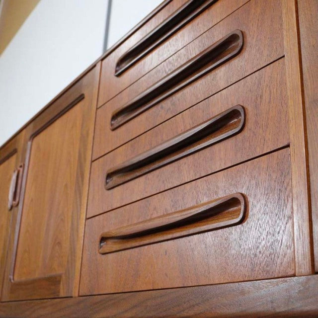 Vintage British mid-century teak sideboard by G-Plan with smooth wood grain and sculpted handles.