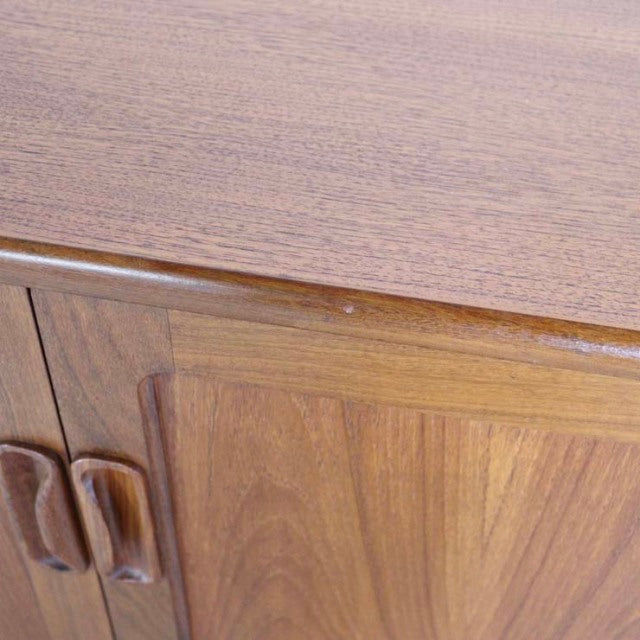 Vintage British mid-century teak sideboard with rich wood grain, rounded handles, and smooth finish.