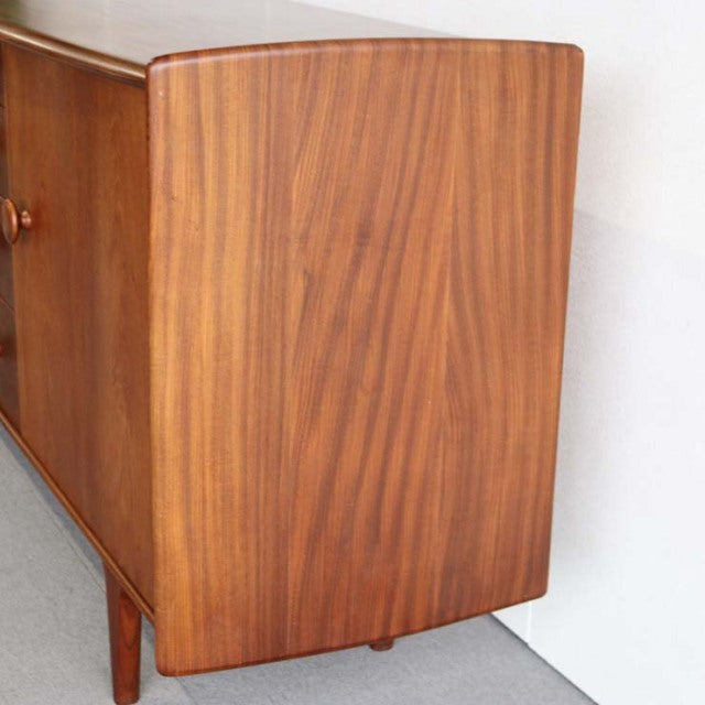 Mid-century vintage teak sideboard with smooth wood grain, rounded edges, and slender British-inspired legs from Denmark.