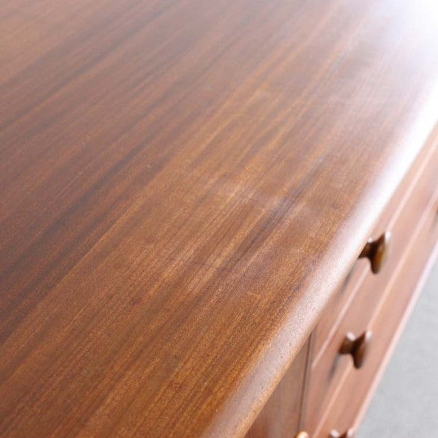 Vintage teak sideboard with smooth grain surface and rounded edges, mid-century British-Denmark design detailing.