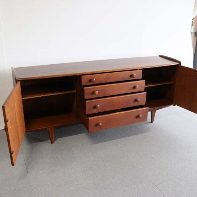 Mid-century vintage teak sideboard with British and Danish design influences, featuring four central drawers and two side.