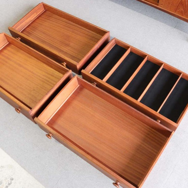 Mid-century vintage teak sideboard with British design, featuring rich wood grain and compartments with black-lined dividers.