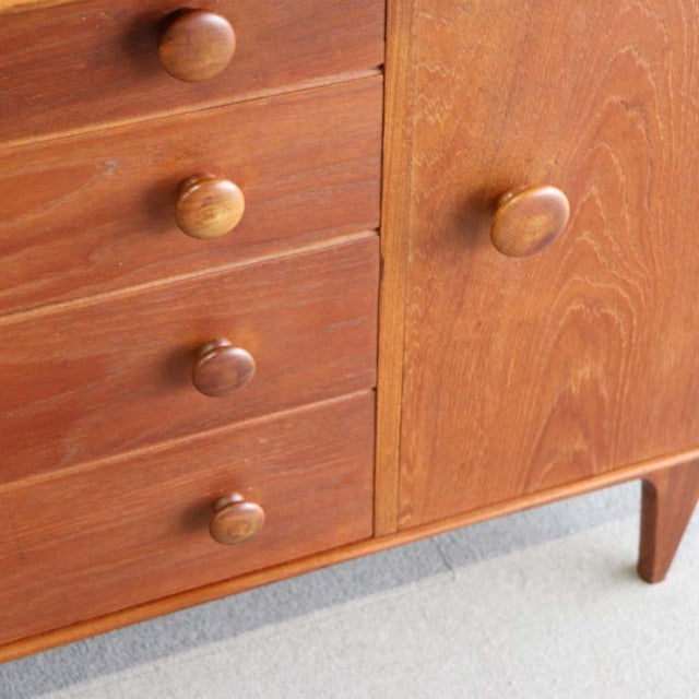 Vintage teak sideboard by Younger with smooth wood grain, round knobs, and tapered mid-century British legs from Denmark.