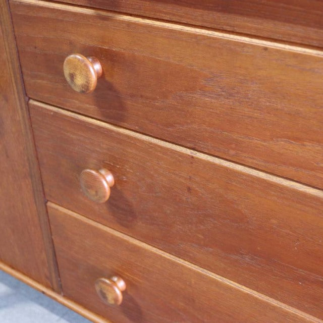 Vintage teak sideboard drawers with round wooden knobs, showcasing mid-century Danish craftsmanship and rich wood grain.