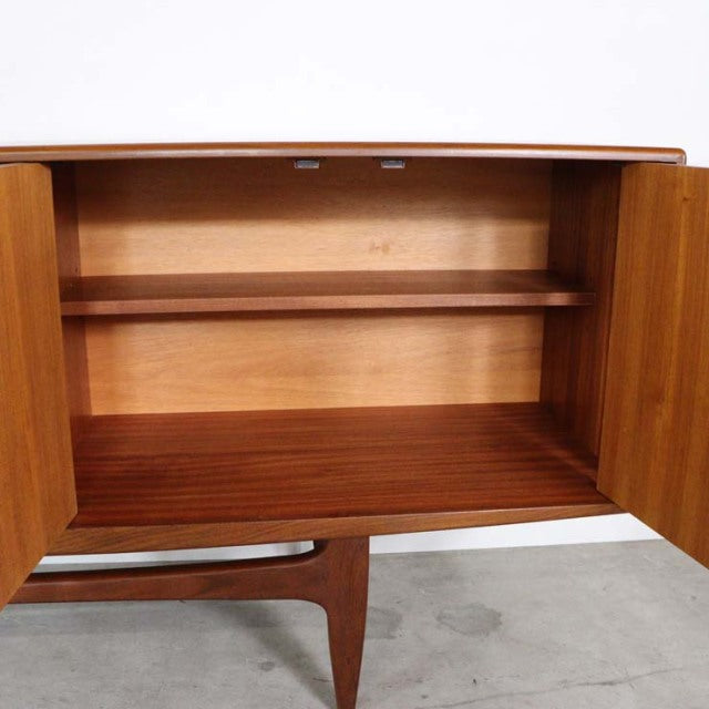 Vintage G-Plan teak sideboard with open double doors, showcasing smooth wood grain and mid-century British design with.