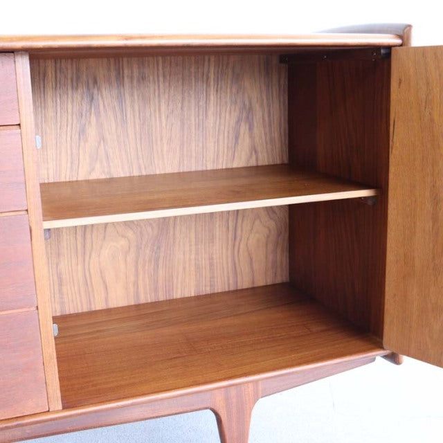 Mid-century British teak sideboard by YOUNGER with rich wood grain, open shelving, and tapered legs.
