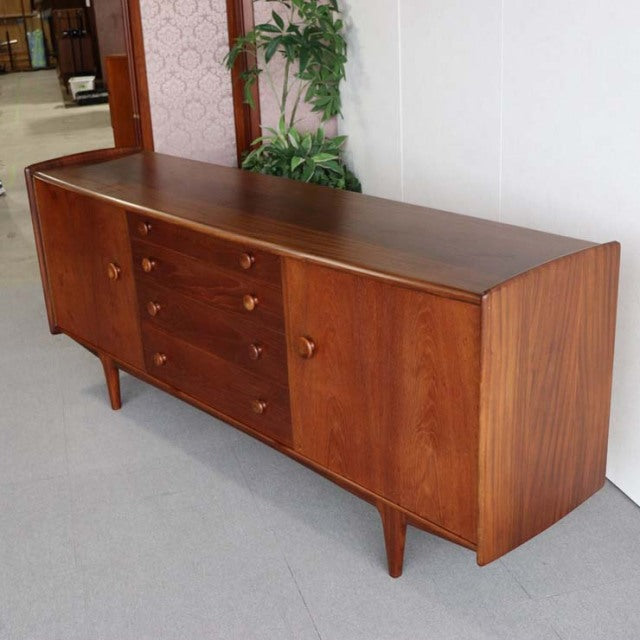 Mid-century teak sideboard by Younger with smooth wood grain, tapered legs, and British-Denmark vintage design.