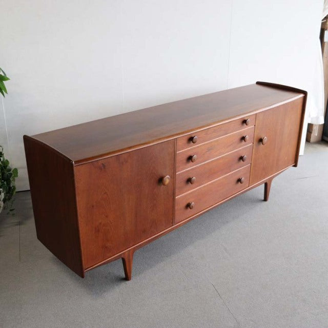 Vintage teak sideboard with British mid-century design, smooth wood grain, tapered legs, and clean rectangular form.