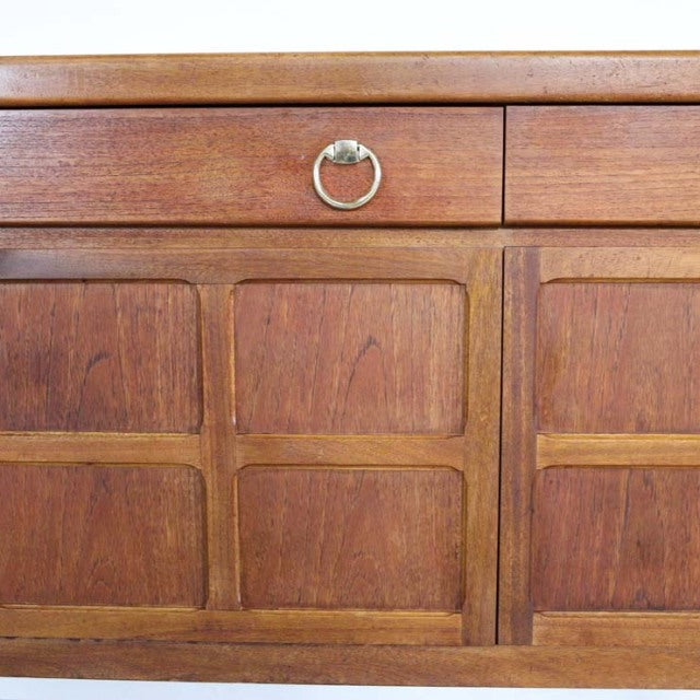 Mid-century British vintage teak sideboard by Nathan with rich wood grain, brass ring pull, and paneled doors.