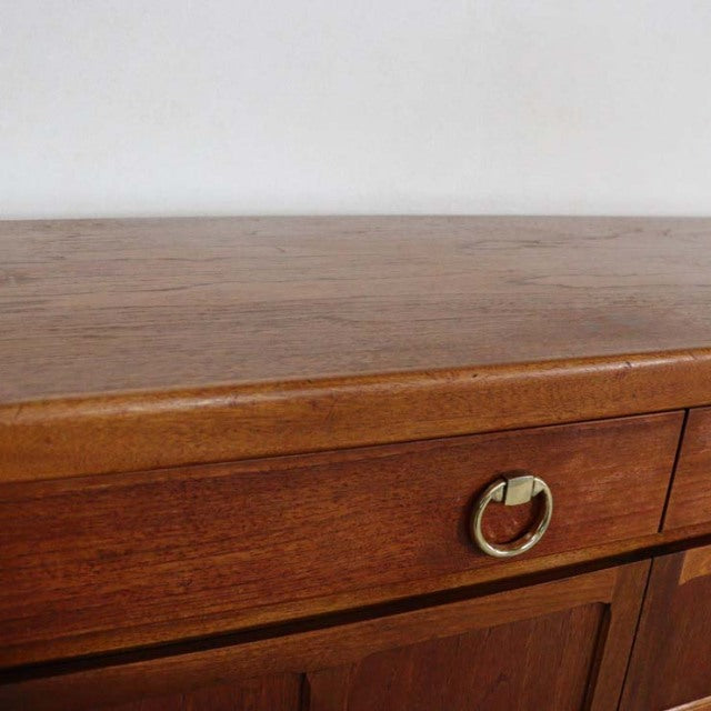 Mid-century British vintage teak sideboard with warm wood grain and brass ring drawer handle.