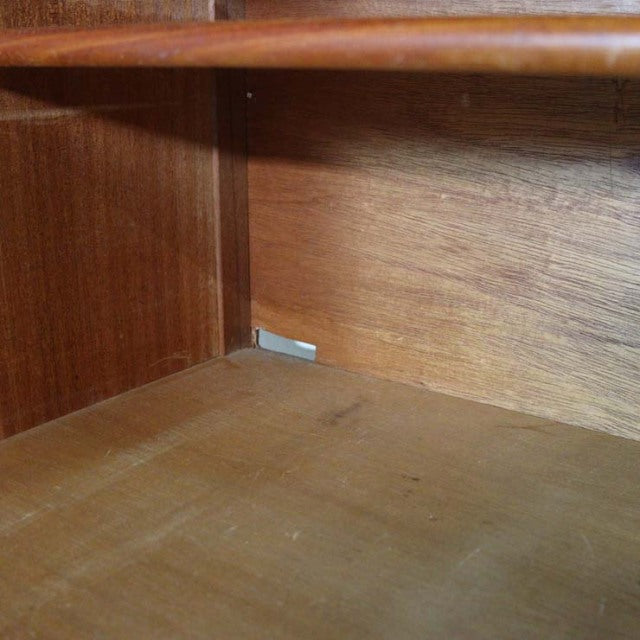 Close-up of vintage teak wood grain inside mid-century British Nathan sideboard, smooth finish, clean corners.