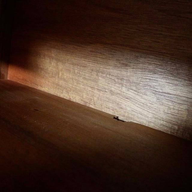 Close-up of vintage Nathan teak sideboard interior showing smooth wood grain and warm mid-century British craftsmanship.