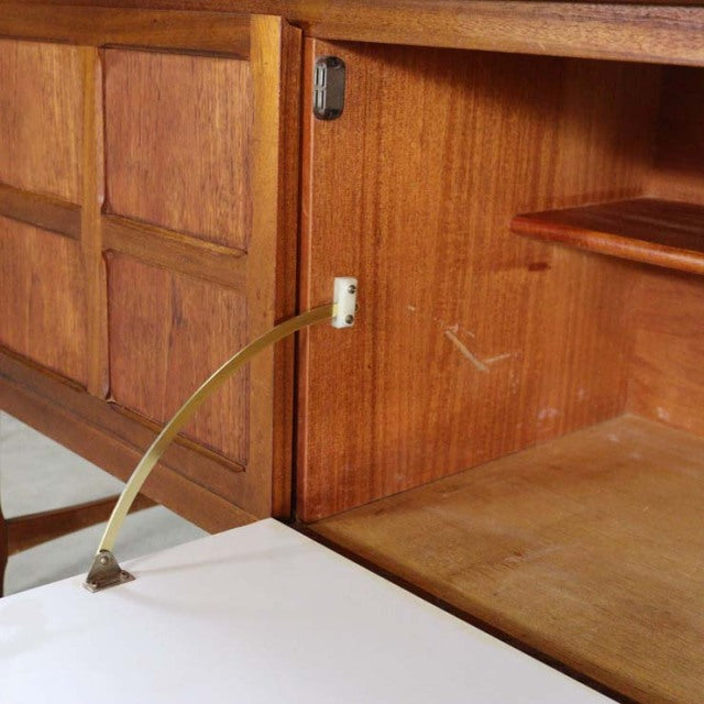 Mid-century British teak sideboard by Nathan with visible wood grain, brass hinge, and clean-lined interior shelves.