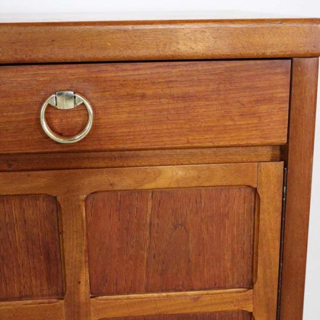 Vintage teak British mid-century sideboard drawer with brass ring pull and rich wood grain detail.