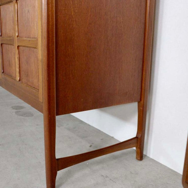 Close-up of mid-century British Nathan teak sideboard leg with warm wood grain and clean lines.