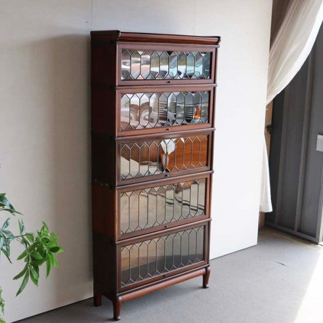 Vintage teak Globe Wernicke glass bookcase with British mid-century design, decorative leaded glass panels, and slender.