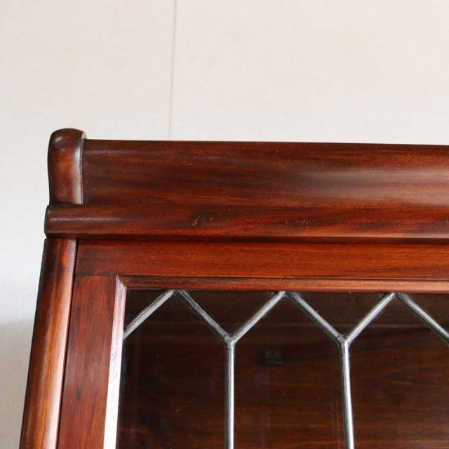 Vintage mid-century Globe Wernicke teak glass bookcase with British design, detailed wood grain, and geometric leaded glass.