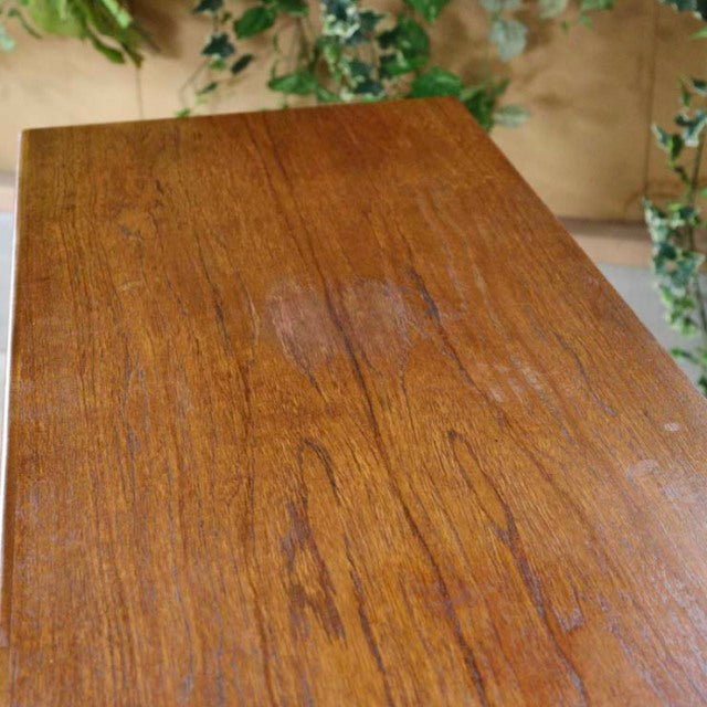 Close-up of vintage British mid-century teak sideboard top with rich natural wood grain and warm honey tones.