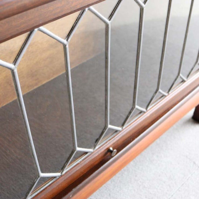 Vintage Globe-Wernicke teak glass bookcase with British mid-century design, geometric leaded glass panels, and polished wood .