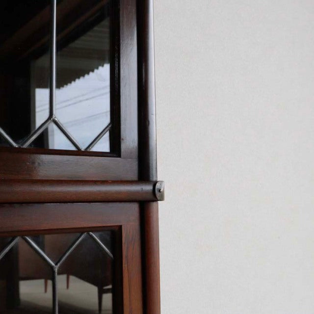 Vintage Globe Wernicke teak glass bookcase with British mid-century diamond-pane glass and rich wood grain detail.