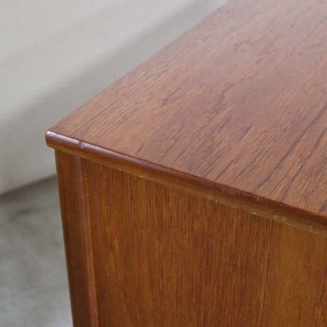 Close-up of vintage British Nathan teak sideboard corner showing warm wood grain and smooth mid-century finish.
