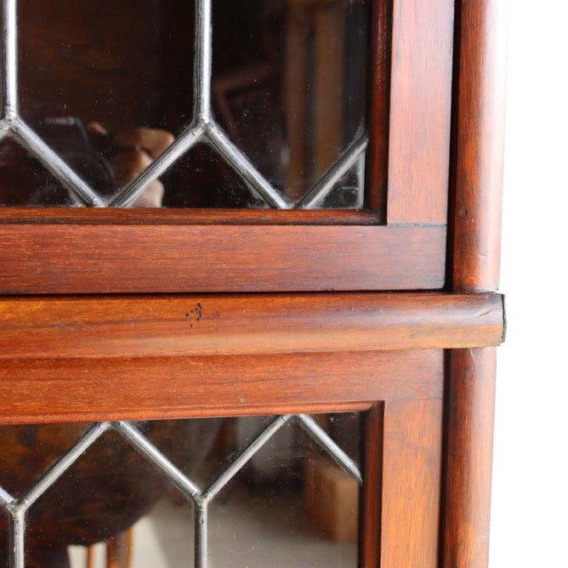 Vintage teak Globe-Wernicke glass bookcase corner with British mid-century wood grain and metal leaded glass panels.