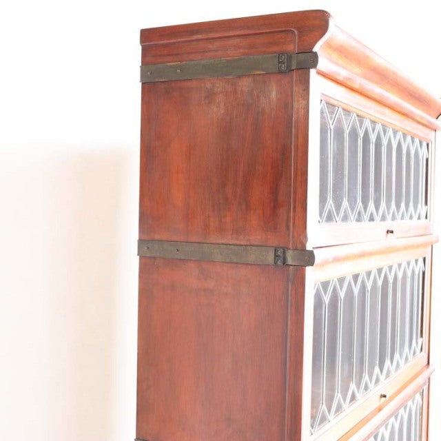 Mid-century British Globe Wernicke teak glass bookcase with diamond-patterned glass panels and brass hardware.