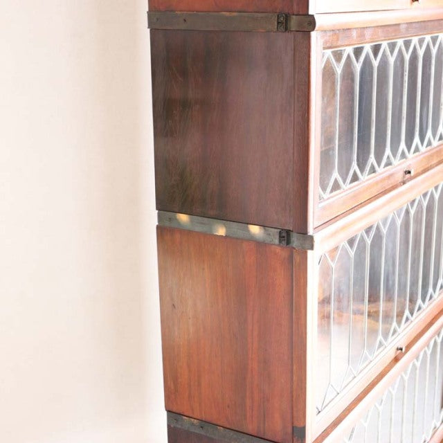 Vintage teak Globe-Wernicke glass bookcase with British mid-century design, rich wood grain, metal corner brackets, and.