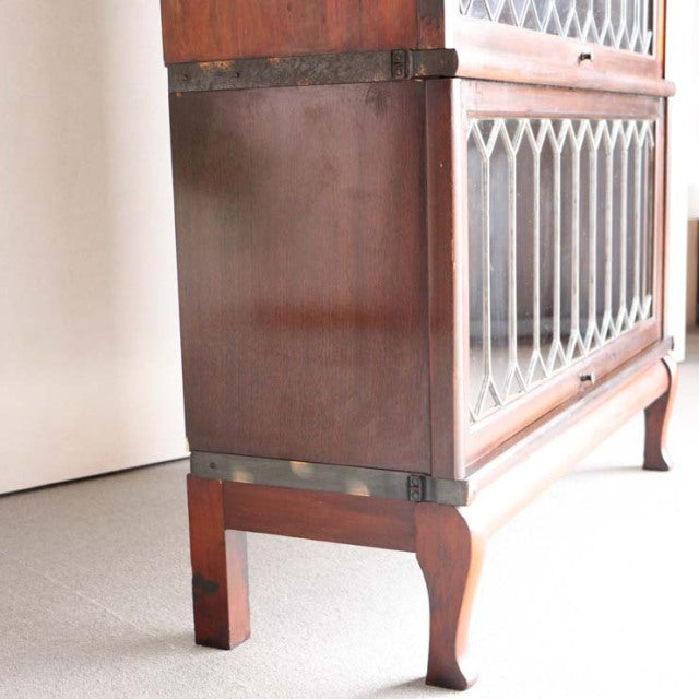 Vintage British Globe Wernicke teak glass bookcase with mid-century wood grain, metal trim, and cabriole legs.