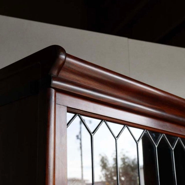 Mid-century British teak Globe Wernicke glass bookcase corner with rich wood grain and leaded glass panels.