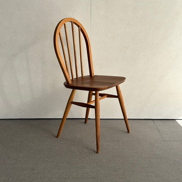Vintage British mid-century teak Ercol hoop back chair with four vertical spindles and tapered legs.